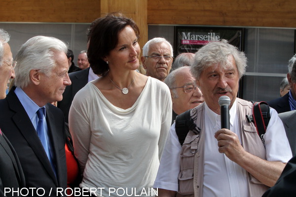 Serge Assier au micro présente son exposition entouré de Laure-Agnès Caradec, représentant le maire de Marseille, Jean-Claude Gaudin et du président de la Communauté urbaine Marseille Provence métropole, Eugène Caselli