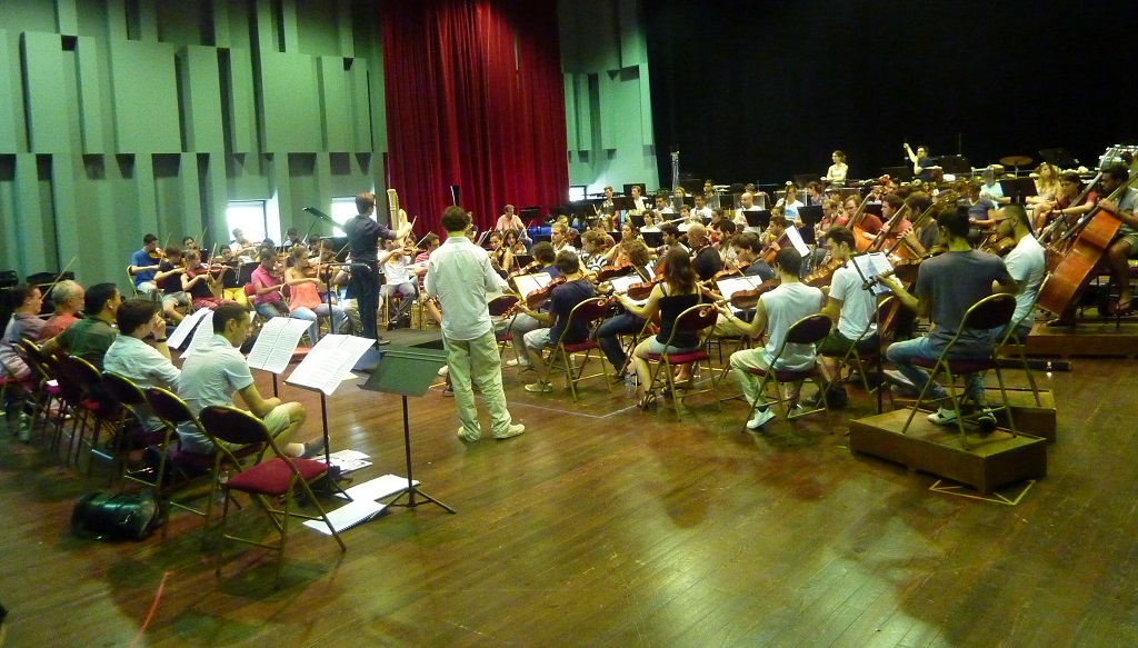 Première répétition « tutti » mercredi après-midi dans le studio Big One du Grand Théâtre de Provence. Face à l’orchestre, sagement alignés, les professionnels qui encadrent les jeunes musiciens. Le matin, tous ont travaillé instruments par instruments. Au long de ces répétitions, les musiciens expérimentés n’hésitent pas à aller donner des conseils aux jeunes, à rectifier des positions, à expliquer… Ce travail va durer pendant une semaine entière (Photo M.E.)