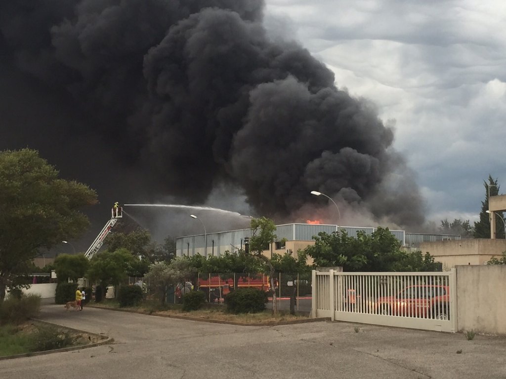 Une importante fumée se dégage de cet entrepôt de résine et de solvants en feu à Eguilles (Photo Michel Egéa)