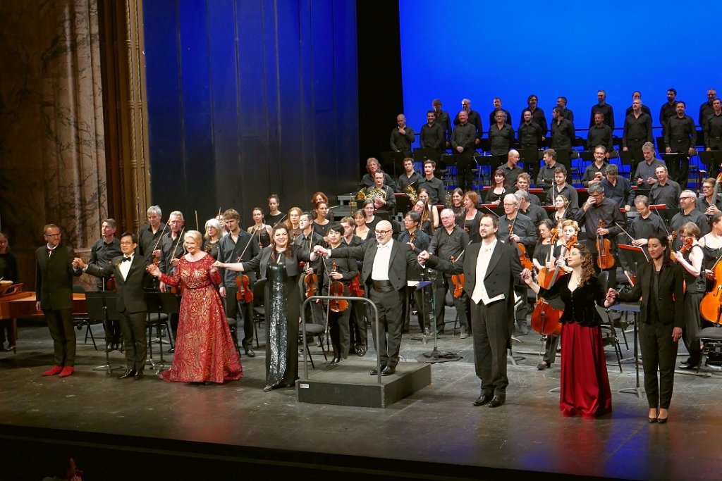 Devant le chœur masculin et l’orchestre, aux saluts (de g. à dr.) Emmanuel Trenque (chef de chœur), Shi Yijie, Annick Massis, Daniela Barcellona, Giuliano Carella, Patrick Bolleire, Viktoria Yarovaya et Ahlima Mhamdi (Photo Christian Dresse)