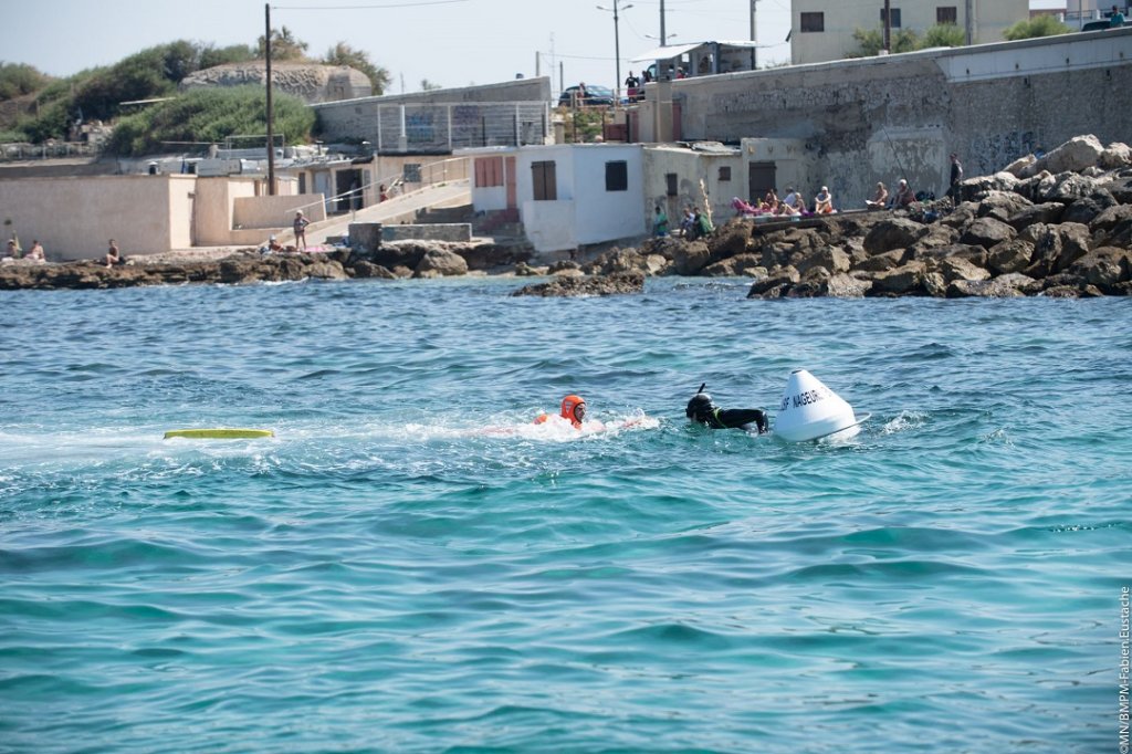 Un nageur en détresse accroché à une bouée de repos rejoint par un marin-pompier (BMPM/SM Eustache)