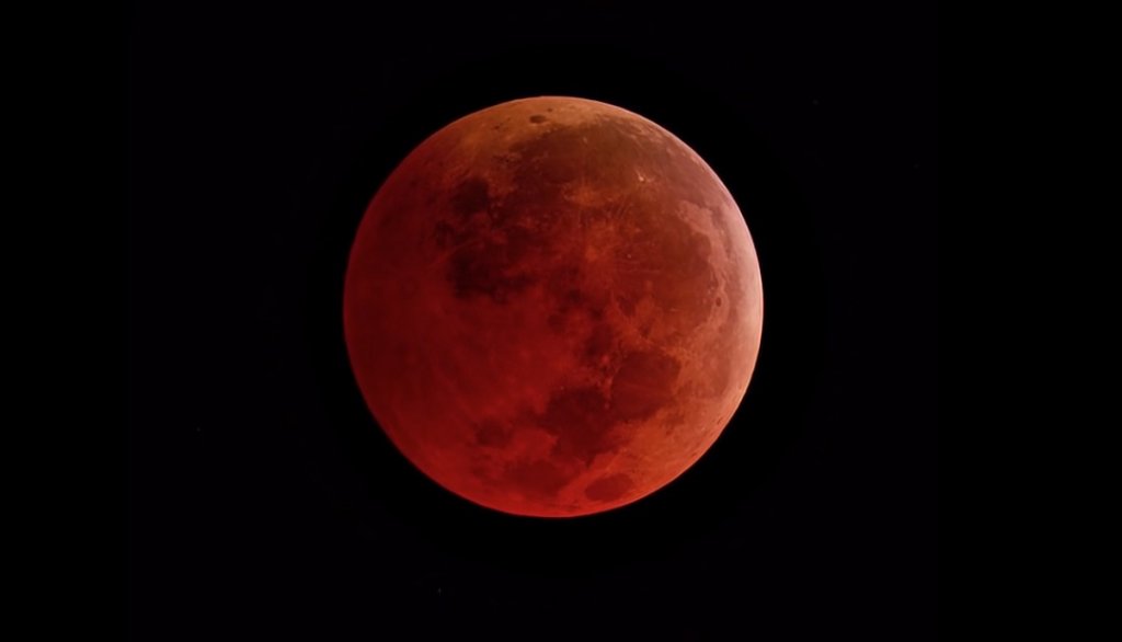 As the Moon moves completely into the umbra, it turns a reddish-orange color. Credit: NASA