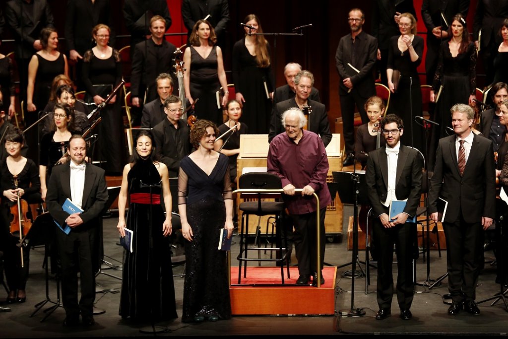 Au moment des saluts, devant l’orchestre et Michel Corboz en chemise carmin, de g. à dr., les solistes Marco Alves dos Santos, Ana Quintans, Marianne Beate Kielland, André Baleiro et Hans Jörg Mammel (absent sur la photo : Peter Harvey). (Photo Caroline Doutre)