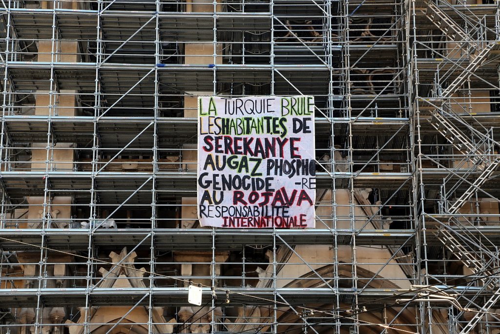 Tuerie de masse dénoncée sur une banderole accrochée aux échafaudages de l’Église des Réformés à Marseille (Photo Robert Poulain)