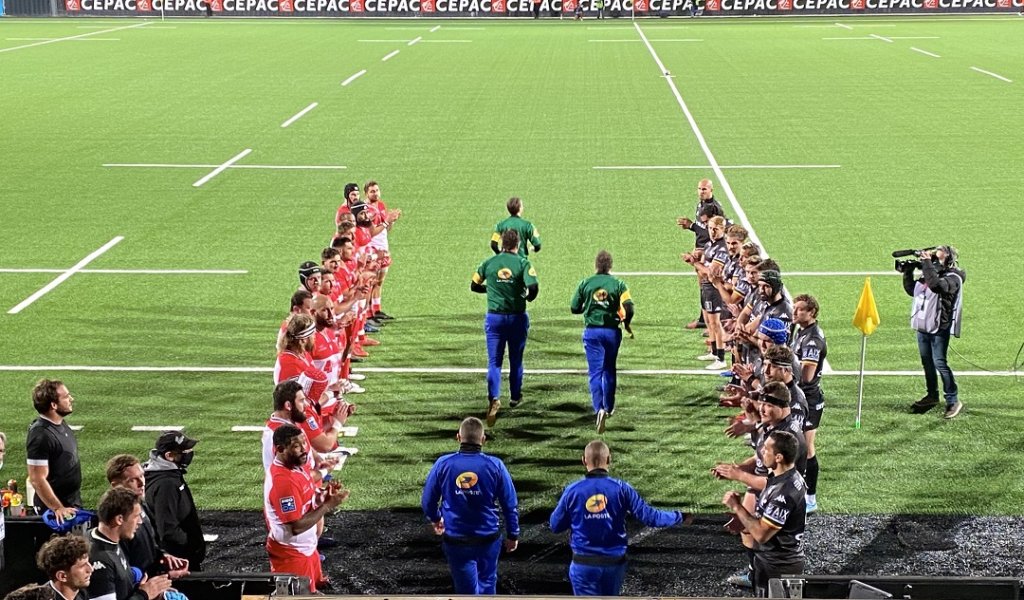 Avant de débuter une minute d’applaudissements en hommage à Christophe Dominici, les joueurs des deux équipes ont formé une haie d’honneur pour l’entrée des arbitres sur le terrain… Journées de l’arbitrage oblige. Photo M.E.