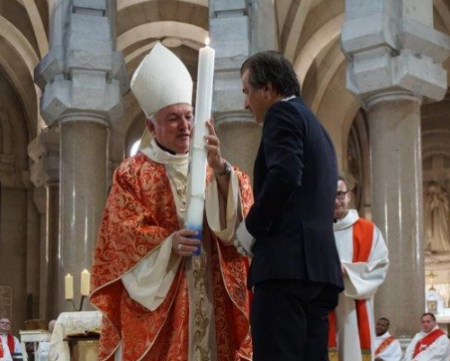 Le président de la CCIAMP, Jean-Luc Chauvin, remet à Mgr Aveline le cierge de cire blanche orné de l’écusson de Marseille (Photo archives Destimed)